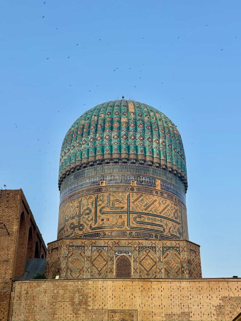 Close-up of the iconic ribbed turquoise dome of the Bibi-Khanym Mosque, featuring intricate blue tilework against a clear blue sky in Samarkand, Uzbekistan