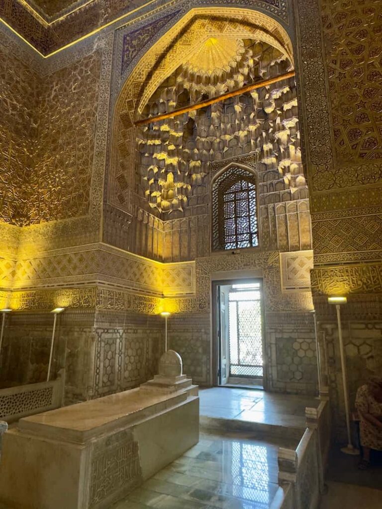 The dark jade tomb stone of Amir Timur (Tamerlane) resting in the center of the golden, intricately carved crypt chamber inside the Gur-e-Amir Mausoleum in Samarkand, Uzbekistan.