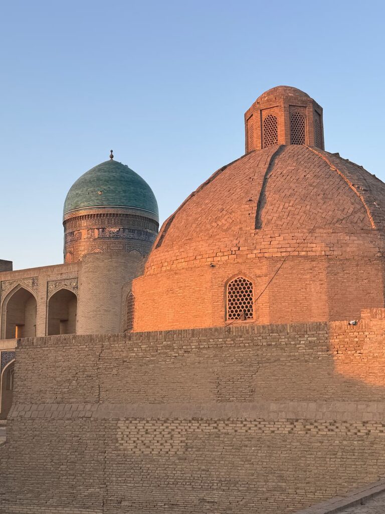 Close-up view of a dome of the Po-i-Kalyan complex in Bukhara, glowing under the warm light of a golden hour sunset.