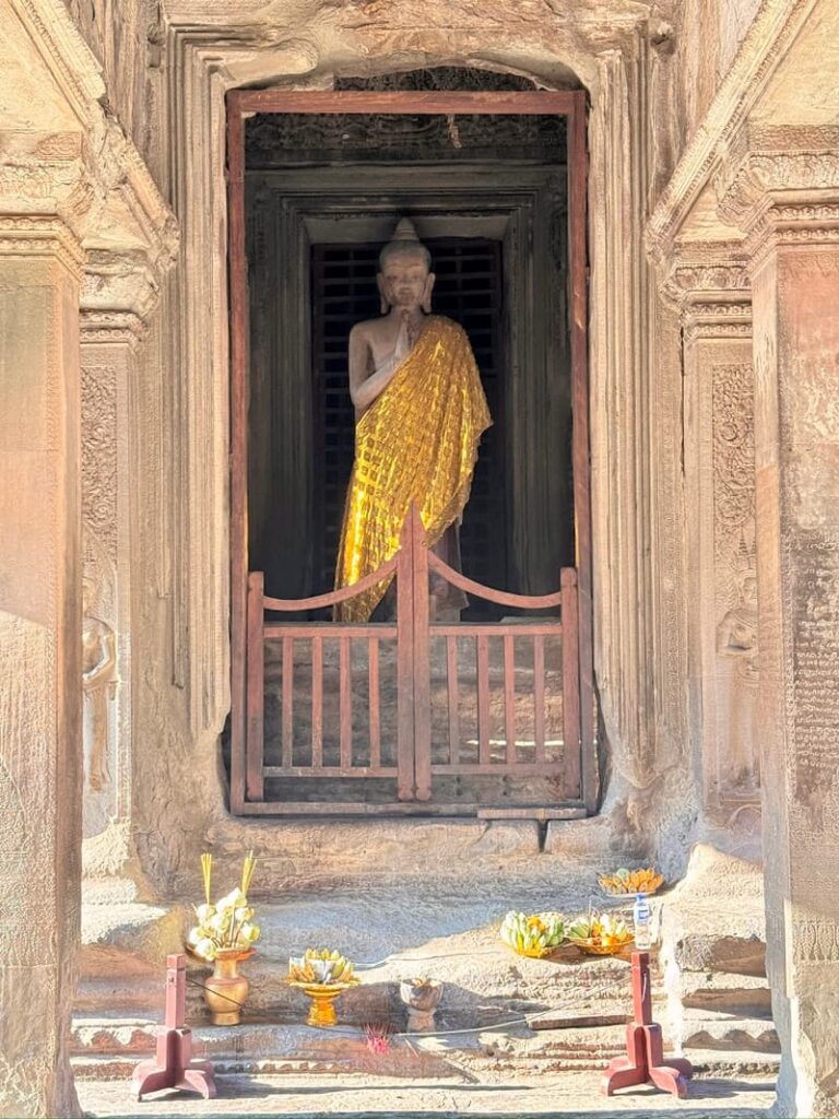 Golden Buddha statue and offerings seen on the upper level during a 2-day Angkor Wat tour in Cambodia.