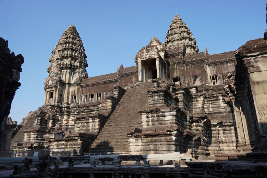 Bakan Sanctuary inside Angkor Wat with a tall staricase to reach the top and the golden Buddha statue