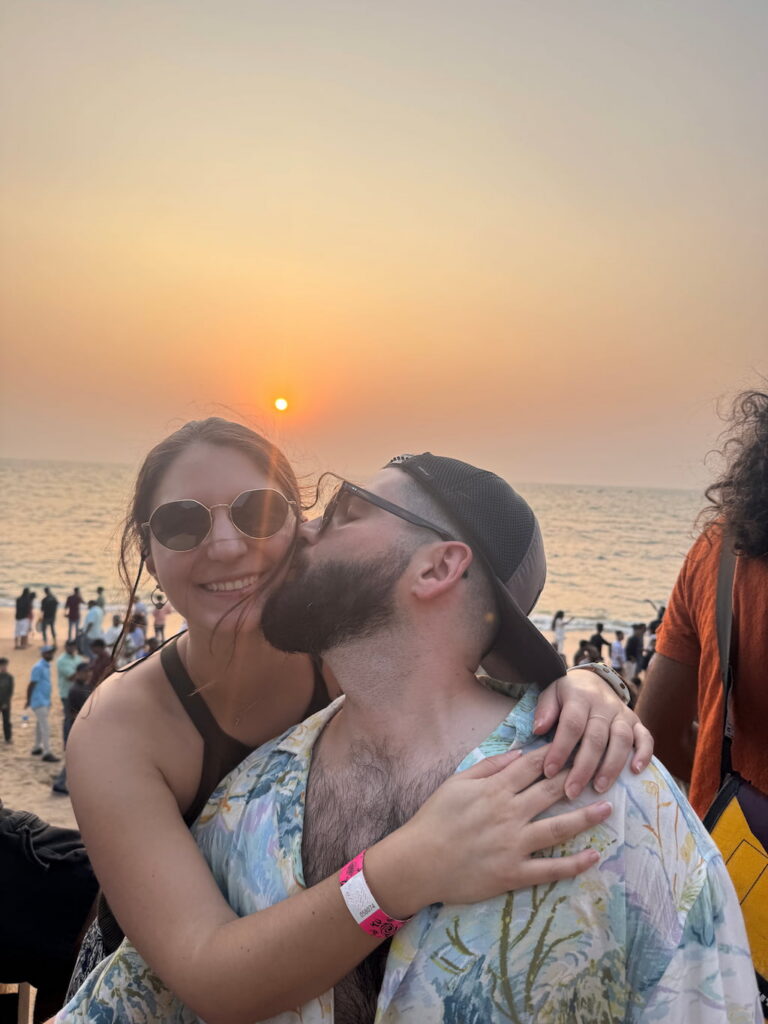 the authors of this travel blog hugging at a psytrance festival in Goa in India, in front of the sunset