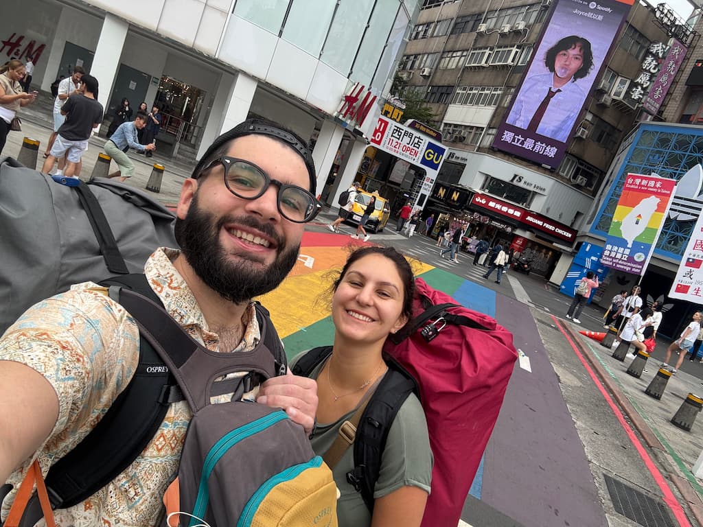 Eleni and Ale, the two authors of this blog, smiling while taking a selfie at a Pride pedestrian street in Taipei, Taiwan