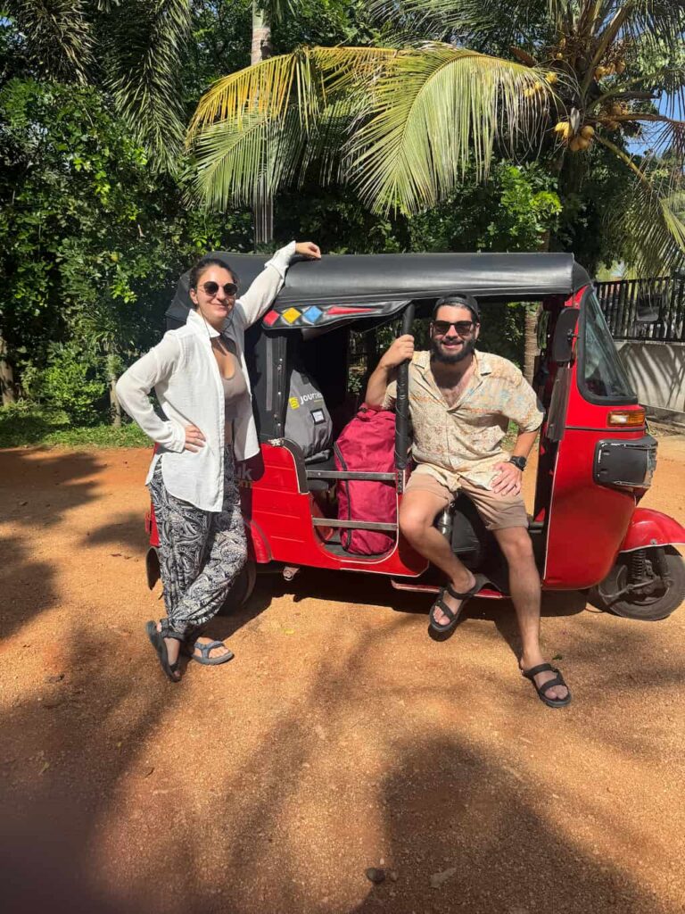 the authors of this travel blog posing at the side of their TukTuk rental in Sri Lanka