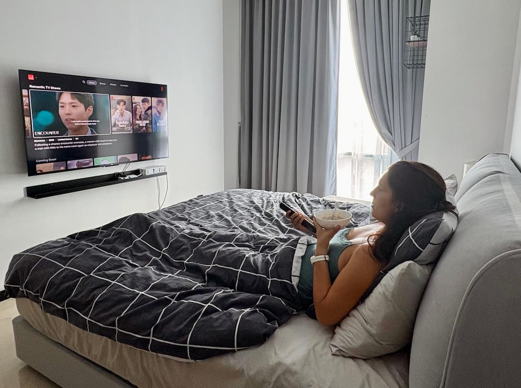 The author of this travel blog watching Netflix movies in bed and resting while having breakfast