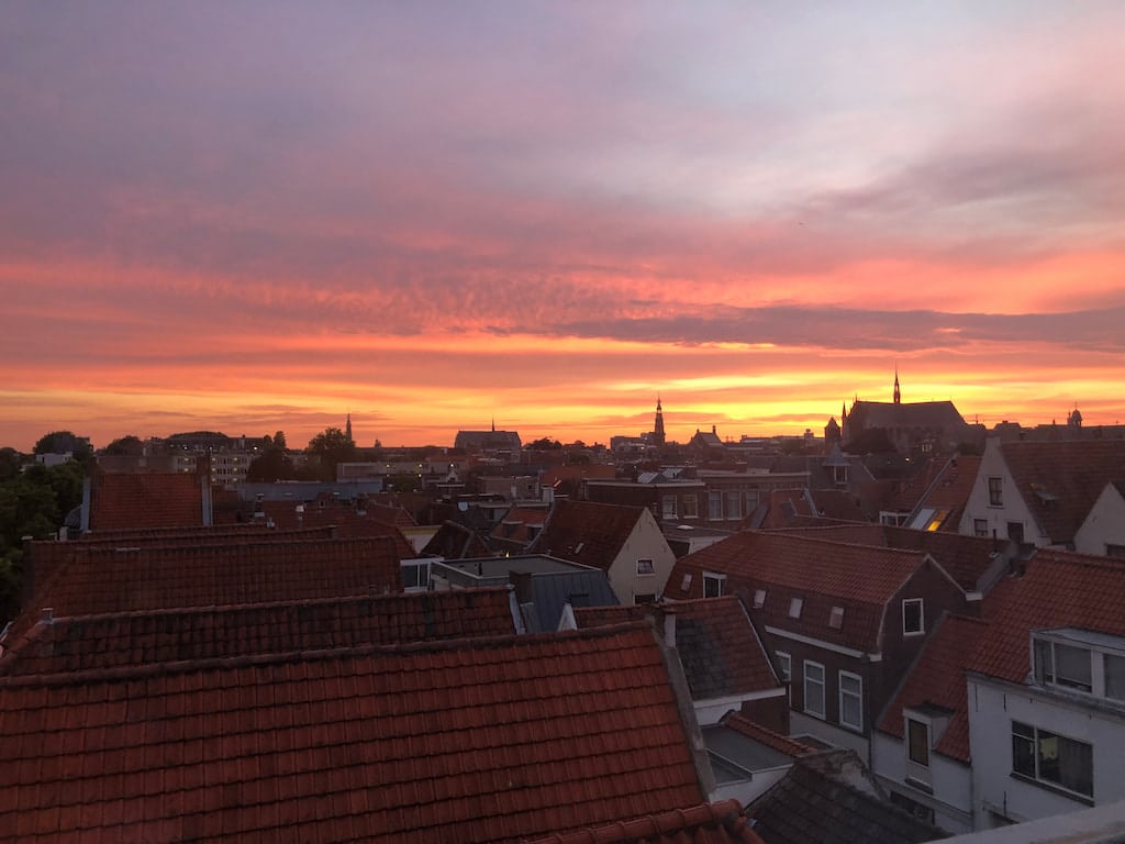 Sunset view with bright pink and yellow colours from our living room in the former home, in Leiden, Netherlands, which we left behind to begin our year-long international travel journey.