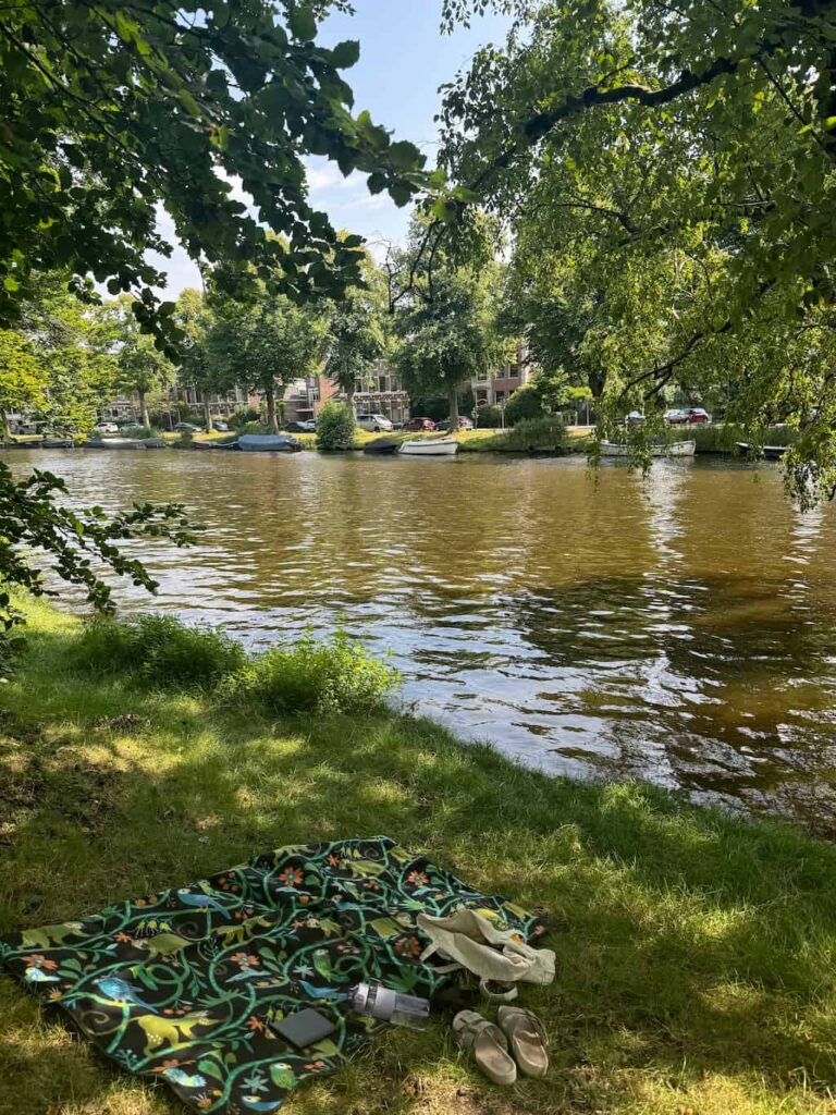 A peaceful picnic scene by a canal in Plantsoen Park, Leiden, where we would often dream of long-term travel.