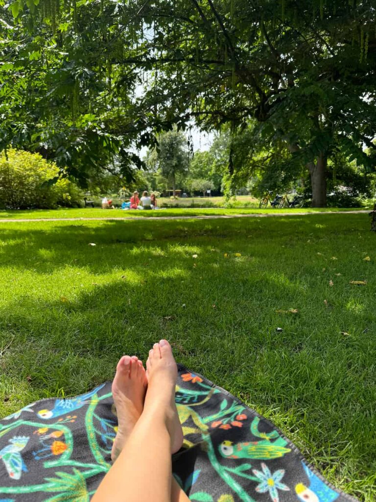the author's feet while lying down at her picnic in Plantsoen park in Leiden, when I decided to quit my job and follow long-term travel.