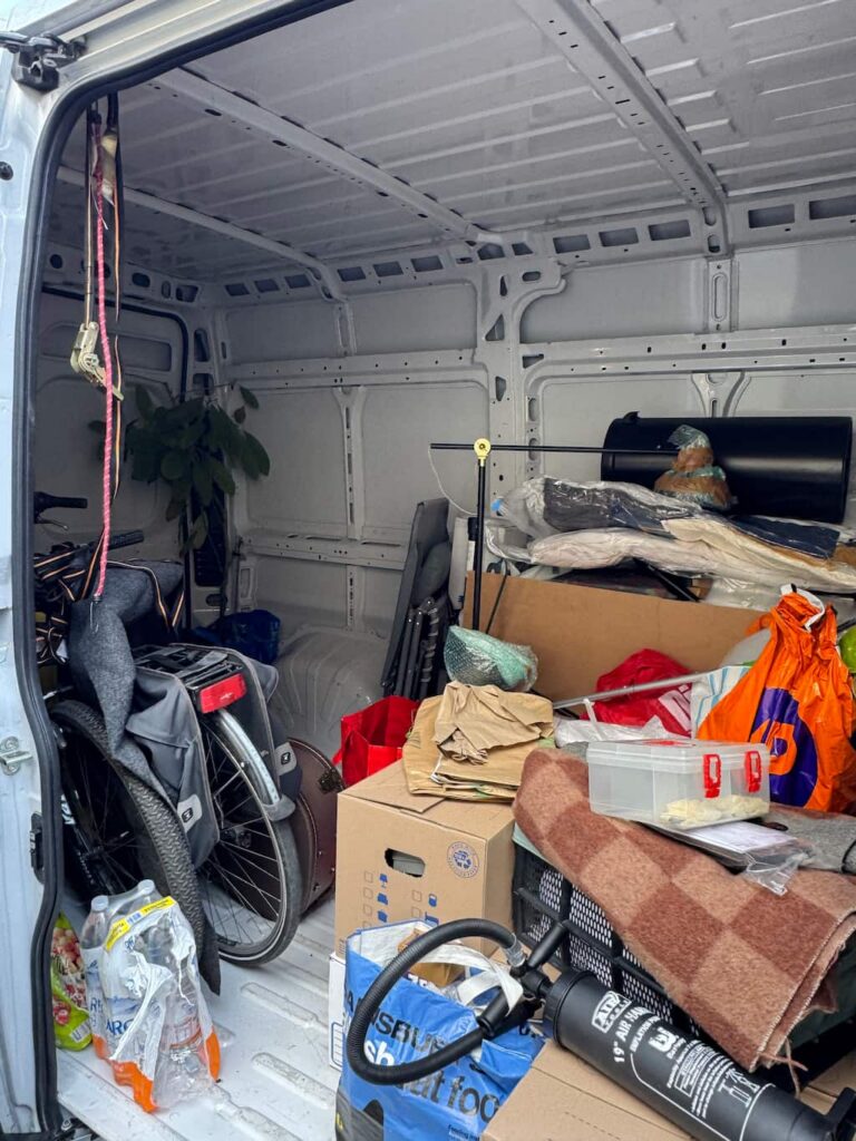 interior of a rental van half full with things the authros of this blog packed and transferred back to Italy, including boxes, a bicycle, plants, a lamp and more