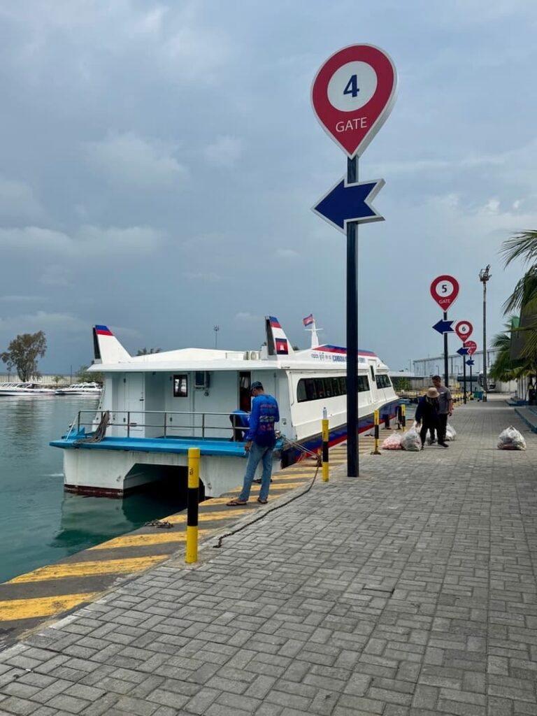 Passenger ferry docked at the pier next to a Gate 4 sign at the Sihanoukville ferry terminal in Cambodia.