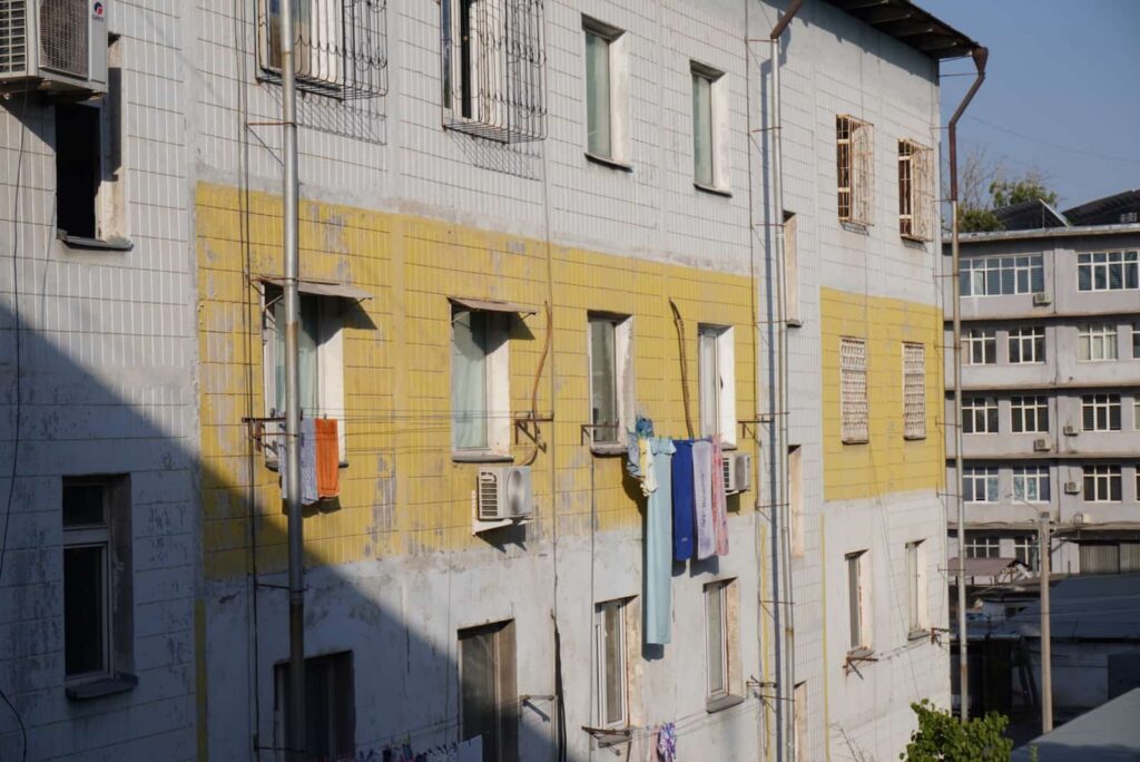 Apartment building with yellow accents and hanging laundry in a local neighborhood of Tashkent