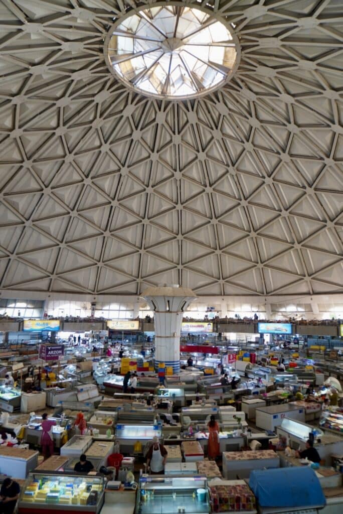 High-angle view of the crowded trading floor and striking geometric dome ceiling inside Chorsu Bazaar.