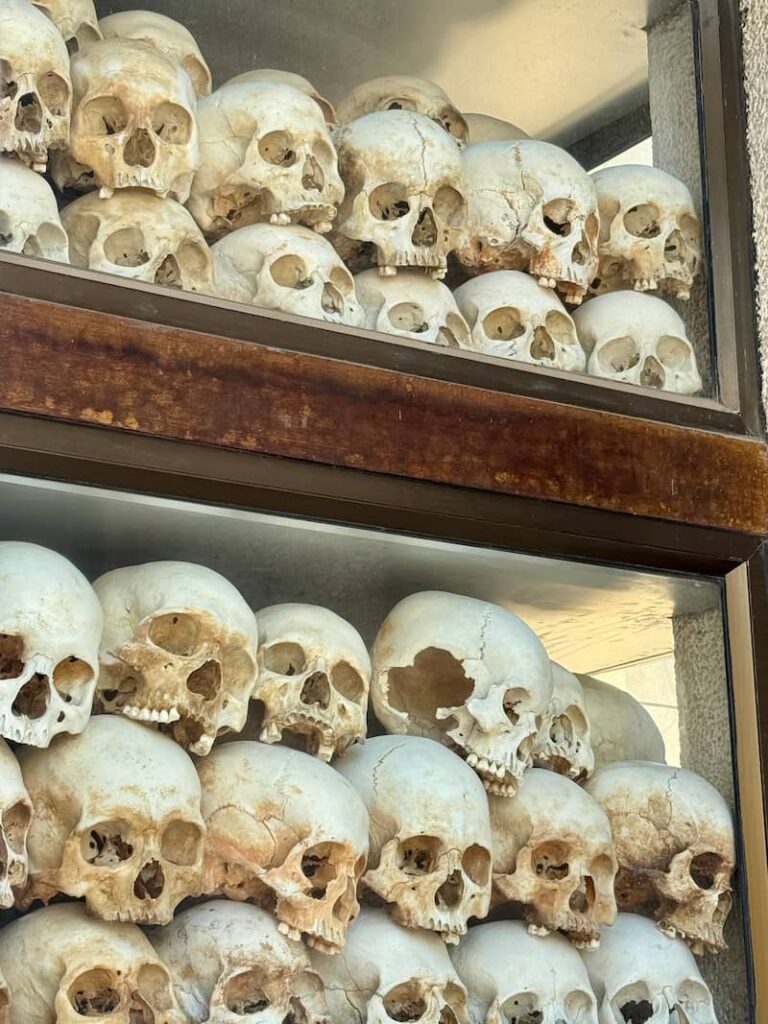 Close-up view of stacked human skulls behind glass inside the memorial stupa at the Choeung Ek Killing Fields.