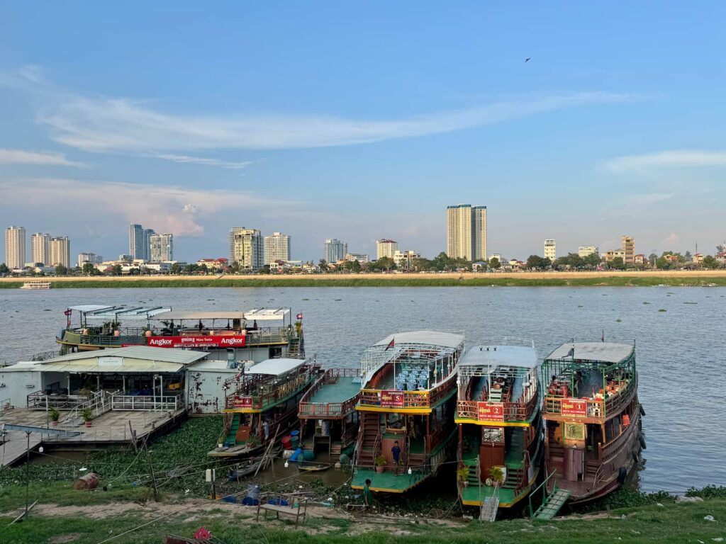 Tour boats and river transport docked along the waterfront in Phnom Penh as featured in our Cambodia Transport Guide.
