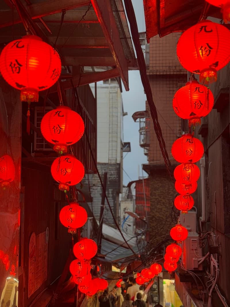 Bright red lanterns hanging along a narrow, historic alleyway in Jiufen, Taiwan