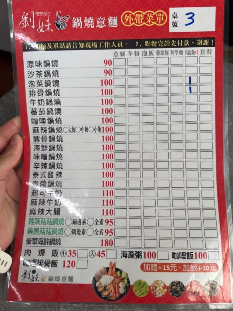 A red laminated menu sheet titled listing various noodle soup options, prices, and checkmarks next to selected items in Taiwan.