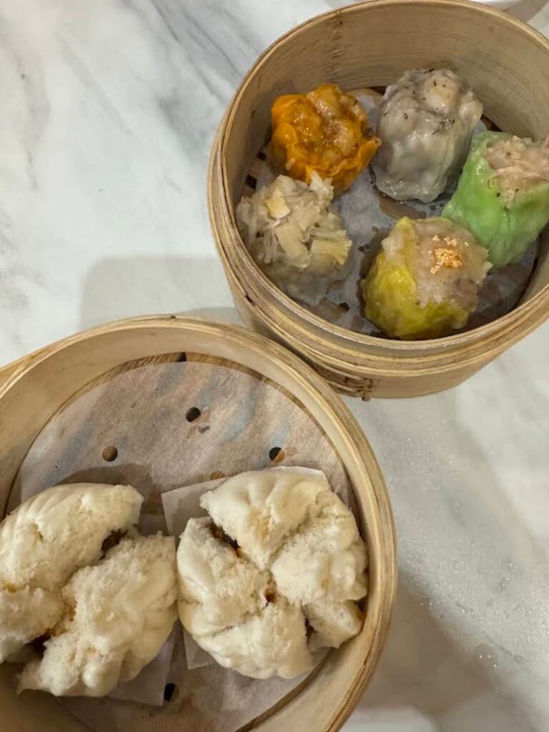 Variety of colorful dumplings and fluffy steamed buns served in bamboo steamers at a restaurant in Taipei, as featured in our guide about the best places to eat in Taipei. 